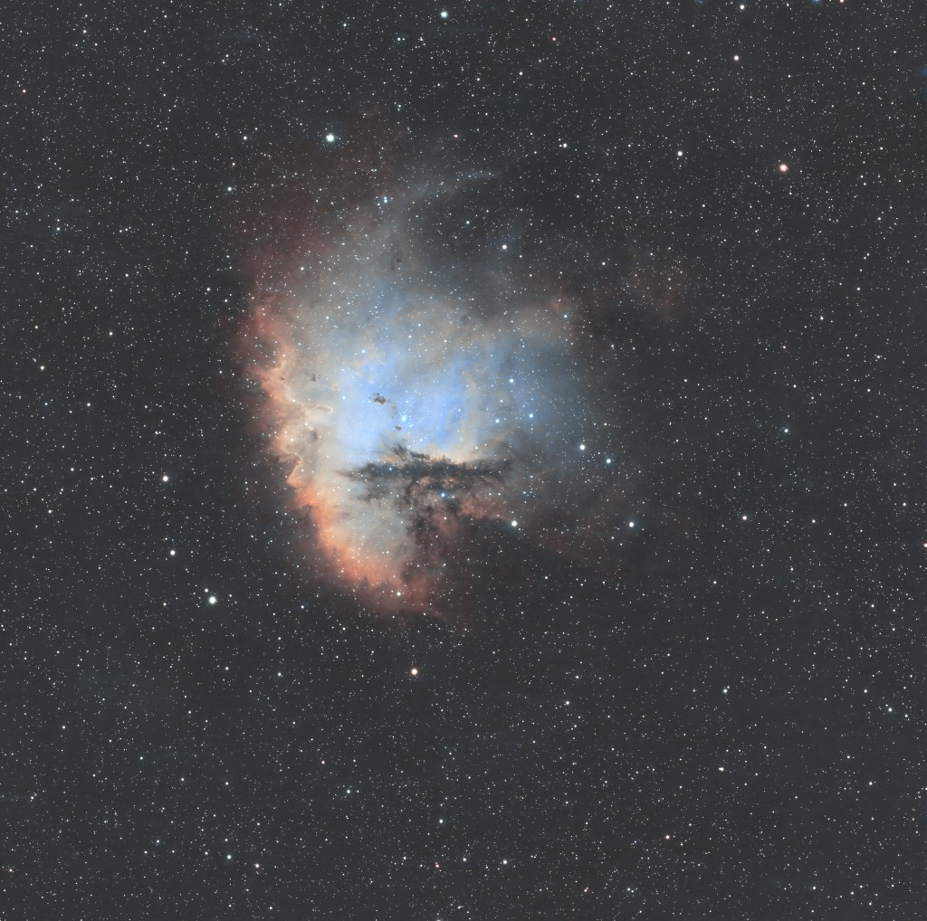 Astrophotography of the Pacman Nebula, a star-forming region resembling the iconic video game character.